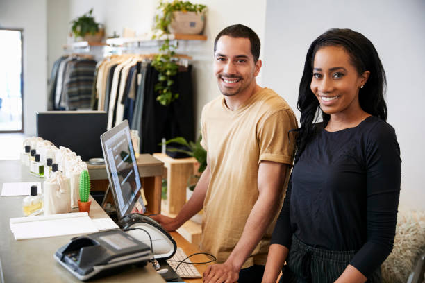 istock Smiling colleagues behind the counter in clothing store 901866548