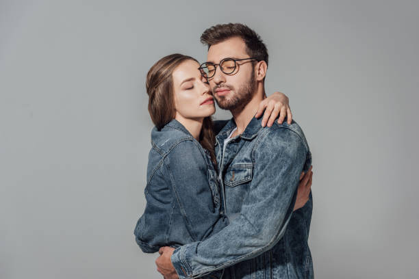 istock couple with closed eyes hugging isolated on grey 901867052
