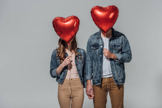istock couple hiding faces behind red heart shaped balloons 901869758