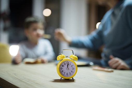 Clock showing the time when mother needs to feed a little boy at home