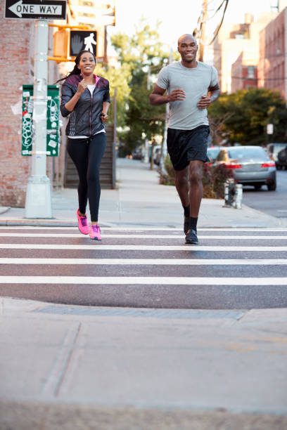 istock Young black couple jogging in Brooklyn, vertical 901870324