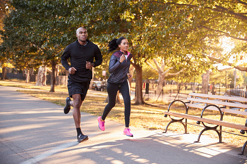 Young black couple jogging in a Brooklyn park