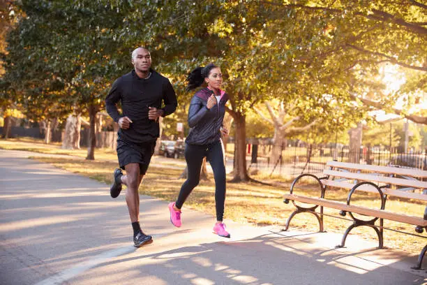 Photo of Young black couple jogging in a Brooklyn park