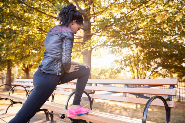 istock Young black woman stretching on a bench in a Brooklyn park 901870576