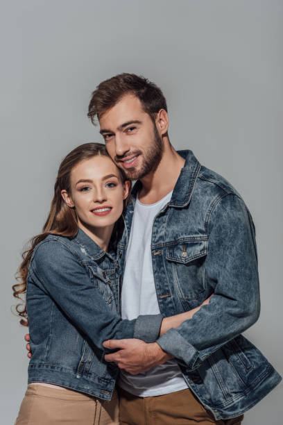istock couple hugging and smiling at camera isolated on grey 901870582
