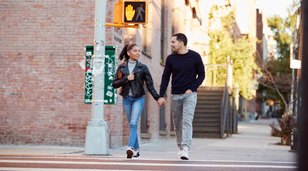 istock Young Hispanic couple walking hand in hand in Brooklyn 901871588