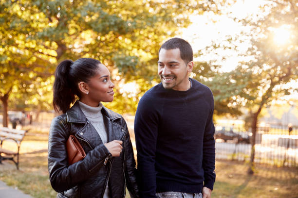 istock Young Hispanic couple walking hand in hand in Brooklyn park 901872092