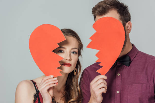 istock couple holding broken heart symbol isolated on grey 901872614