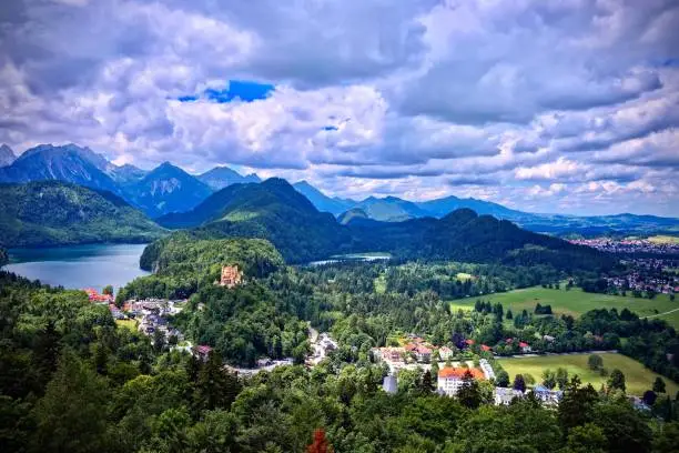 Aerial view of Schwangau with Alpsee in the background under a dark brooding sky
