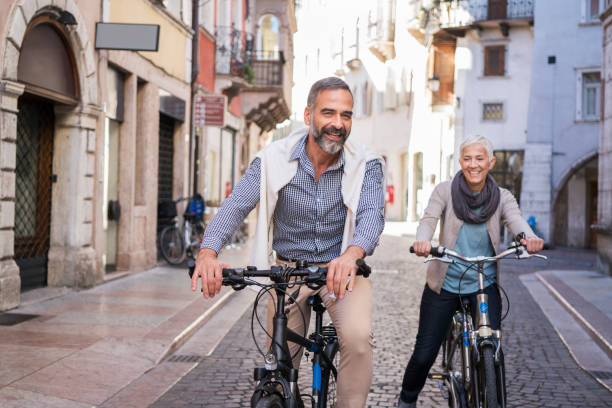 explorar ciudad con bicicleta - couple mature adult europe travel fotografías e imágenes de stock