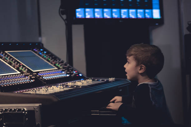 istock Little composer editing music on audio mixer in music studio. 901888652