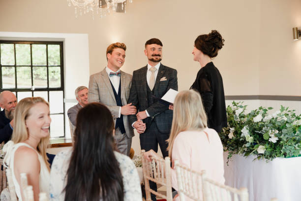 zwei männer, die austausch gelübde am tag ihrer hochzeit - smoking issues fotos stock-fotos und bilder