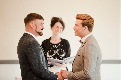 Dos hombres intercambiando votos el día de su boda photo