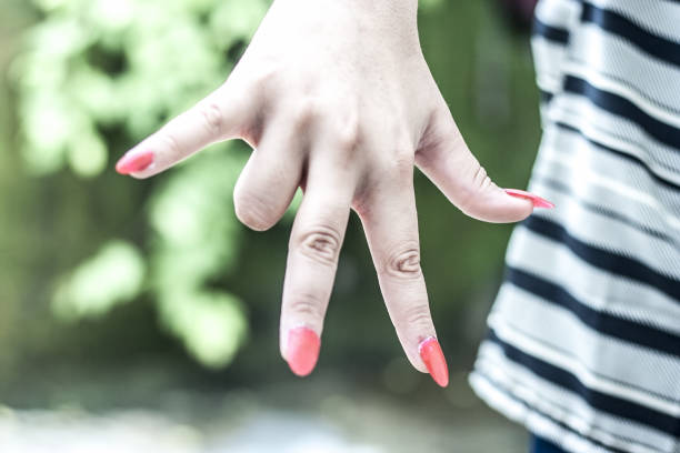 istock A hand wearing fake artificial nails showing them in various positions. 901903518