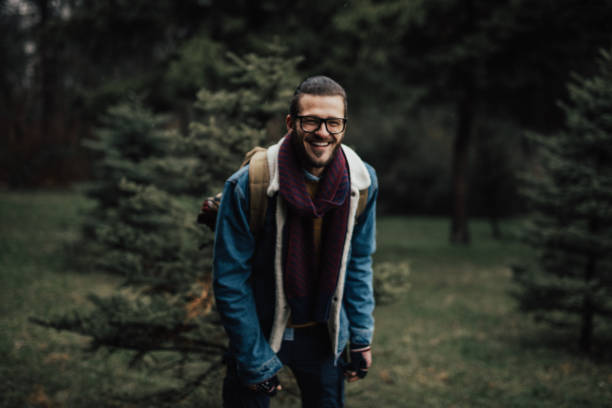 istock Young happy man smiling while standing in forest and looking at the camera 901908722