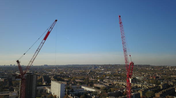 istock Aerial Drone image of a construction worker standing on a very tall tower crane with the London (england) skyline in the background. 901915848