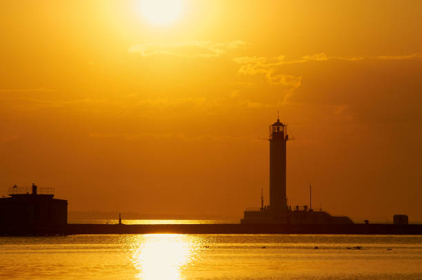 istock Silhouette of shore break and lighthouse at sunrise 901920698