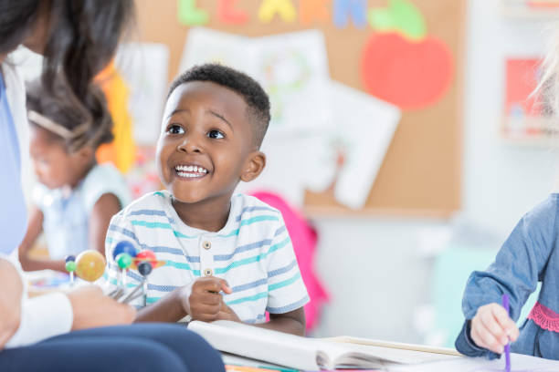 istock Excited little boy studies solar system model with teacher 901926544