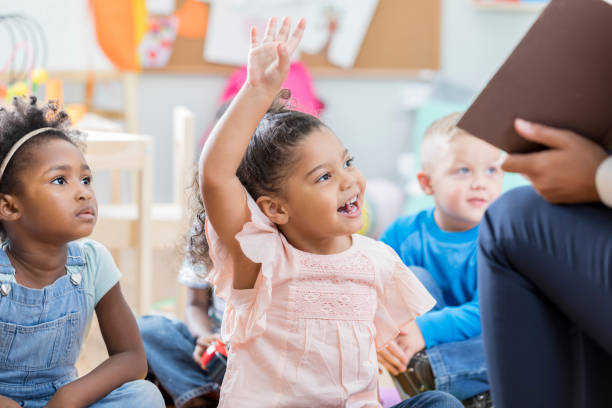 istock Little girl raises hand during story time 901926596
