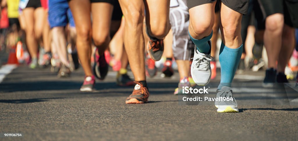 Marathon running race in the light of evening Marathon running race in the light of evening,running on city road detail on legs Marathon Stock Photo