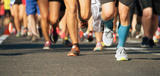 марафонская беговая гонка в свете вечера - running legs стоковые фото и изображения