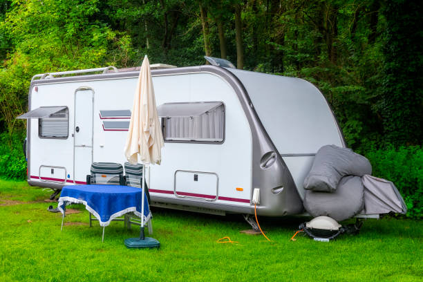 istock Summer holiday with camper trailer in the forest 901937360