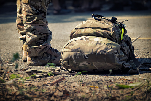 Soldados de pie con la bolsa. Ejército, líneas de botas militares de los soldados de comando en uniformes de camuflaje photo