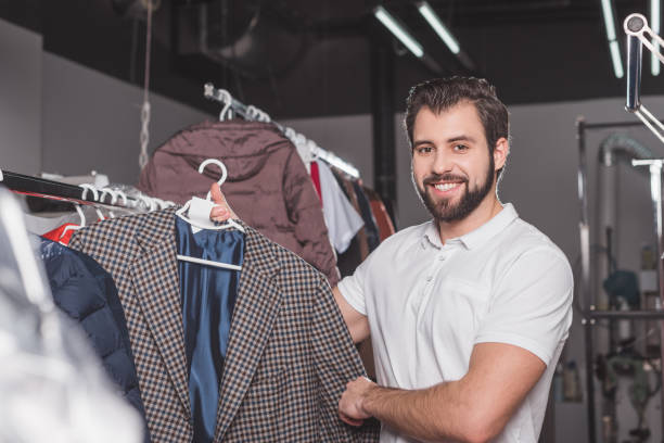 istock happy young dry cleaning worker hanging jacket at warehouse 901942074