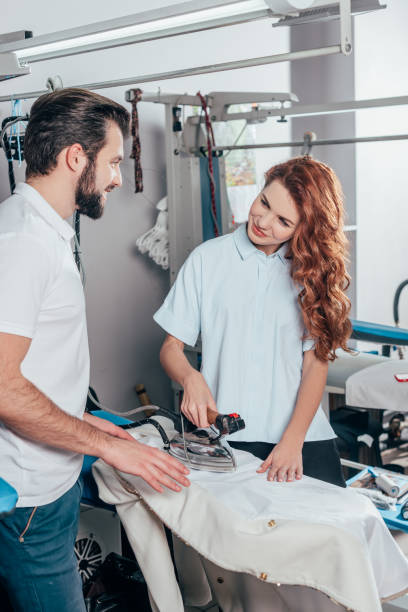 istock happy young dry cleaning workers ironing clothes 901942676
