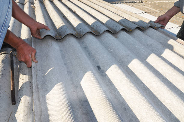 istock Roofers replace damaged asbestos tile. Repair asbestos roof. 901943066