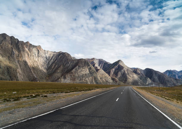 estrada asfaltada com marcações nas montanhas - arid climate asphalt barren blue - fotografias e filmes do acervo