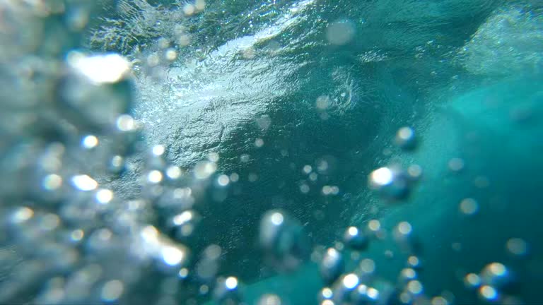 SLOW MOTION UNDERWATER: Crystal clear barrel wave breaking over camera in ocean