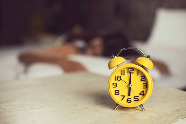 istock Alarm clock with woman sleeping on bed 901950806