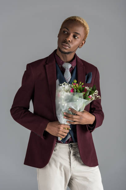 istock man with flowers in hands looking away isolated on grey 901953842