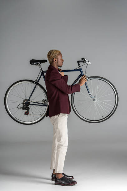 istock man holding bicycle in hands on grey background 901956288