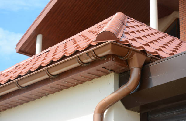 Close up on roof gutter holder and guttering downspout pipe with clay tiles roof. Installing rain gutter. Close up on roof gutter holder and guttering downspout pipe with clay tiles roof. Installing rain gutter. downspout stock pictures, royalty-free photos & images
