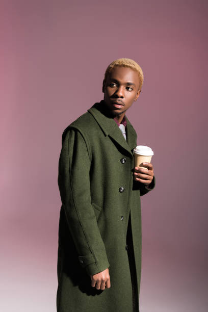 istock man holding paper cup and looking away 901957478