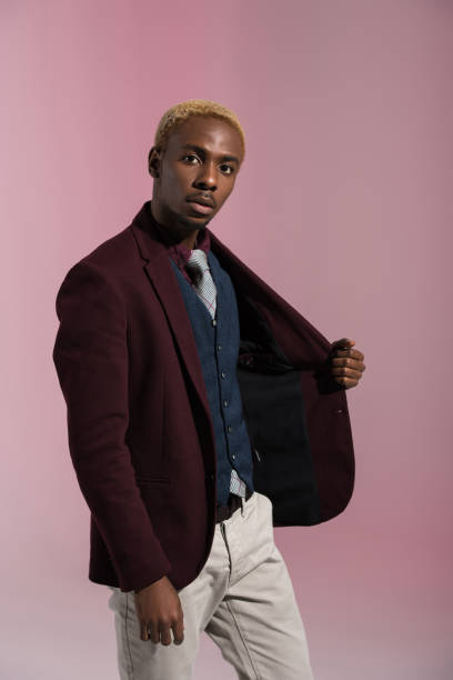 istock man looking at camera while holding side of his jacket 901959186