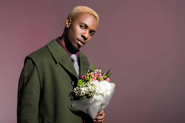 istock man with bouquet of flowers looking at camera 901959704