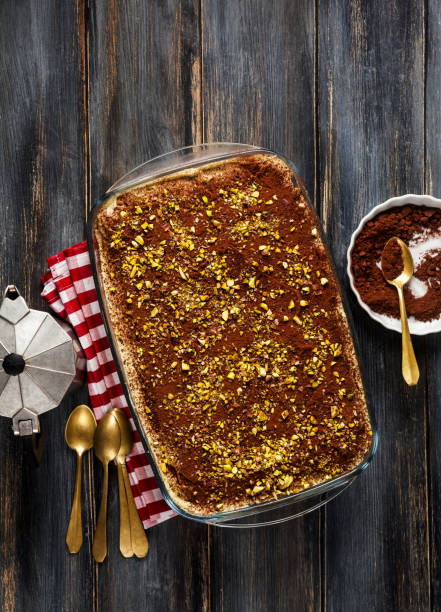 sobremesa tradicional italiana com café, cacau e mascarpone bolo de tiramisu de queijo em uma bandeja em uma mesa de madeira azul. polvilhado com pistache. mocca - biscotti cookie chocolate pistachio - fotografias e filmes do acervo