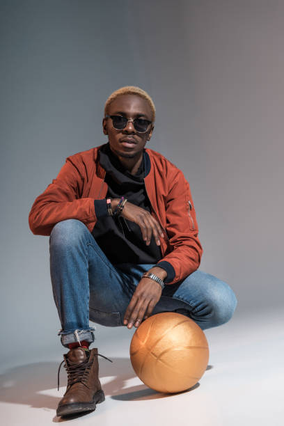 istock man sitting with basketball ball on floor 901963822