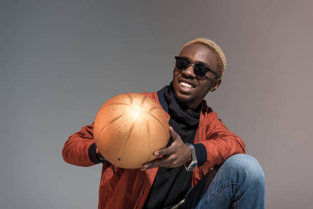 istock man holding basketball ball isolated on light background 901963912