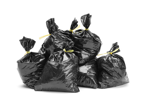 Several Black Trash bags in a Pile Isolated on White.