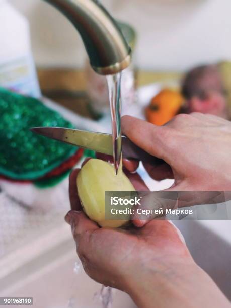 Young Female Hands Peel Potatoes With A Knife Over A Sink Stock Photo - Download Image Now