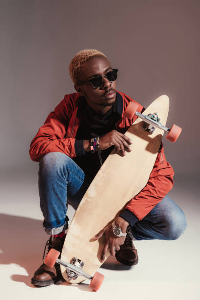istock skateboarder sitting and holding longboard 901968536