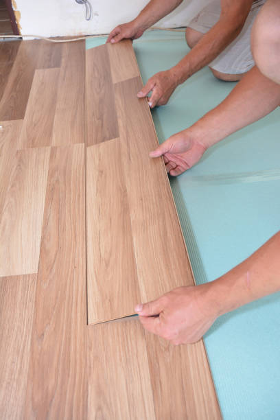 istock Contractors installing wooden laminate flooring with insulation and soundproofing sheets. Man laying laminate flooring. Man laying laminate flooring. 901972834