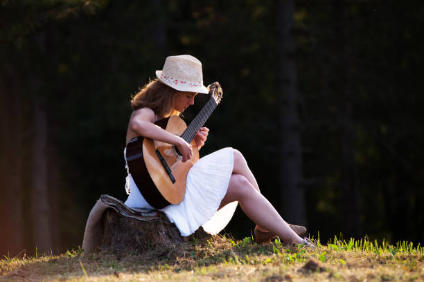 istock Young woman playing guitar 901973282