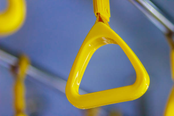 istock Yellow handles on ceiling rails for standing passenger. Handle on the MRT, prevent toppling.underground railway system or metro,people holding onto a handle on a train and the bus. Selective focus 901974220
