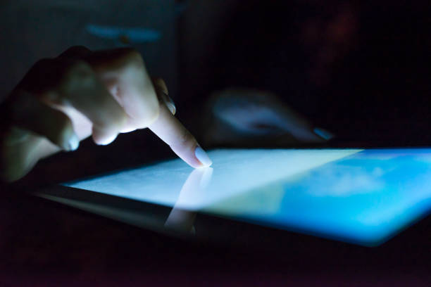 istock Woman's pointing finger with tablet glowing screen at home. 901977604