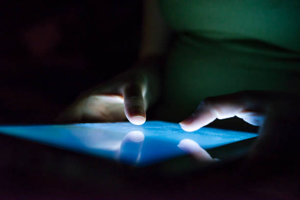 istock Closeup of female hand using tablet at night on bed. 901977790